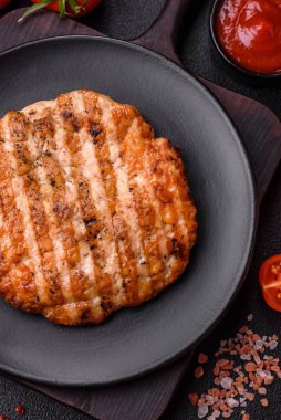 Lezzetli taze ızgara tavuk filetosu, esrarlı baharatlar ve çimento kaplı otlar. Ateşte pişirilmiş bir tabak.