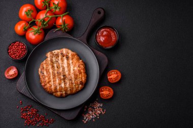 Lezzetli taze ızgara tavuk filetosu, esrarlı baharatlar ve çimento kaplı otlar. Ateşte pişirilmiş bir tabak.