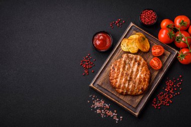 Lezzetli taze ızgara tavuk filetosu, esrarlı baharatlar ve çimento kaplı otlar. Ateşte pişirilmiş bir tabak.