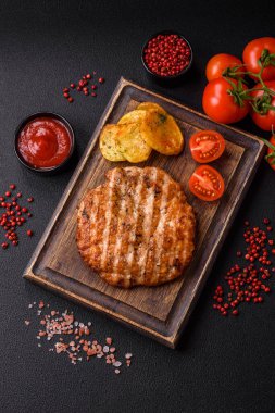 Lezzetli taze ızgara tavuk filetosu, esrarlı baharatlar ve çimento kaplı otlar. Ateşte pişirilmiş bir tabak.