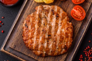 Lezzetli taze ızgara tavuk filetosu, esrarlı baharatlar ve çimento kaplı otlar. Ateşte pişirilmiş bir tabak.