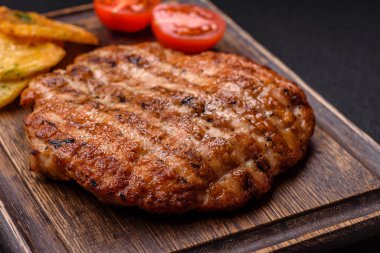 Lezzetli taze ızgara tavuk filetosu, esrarlı baharatlar ve çimento kaplı otlar. Ateşte pişirilmiş bir tabak.