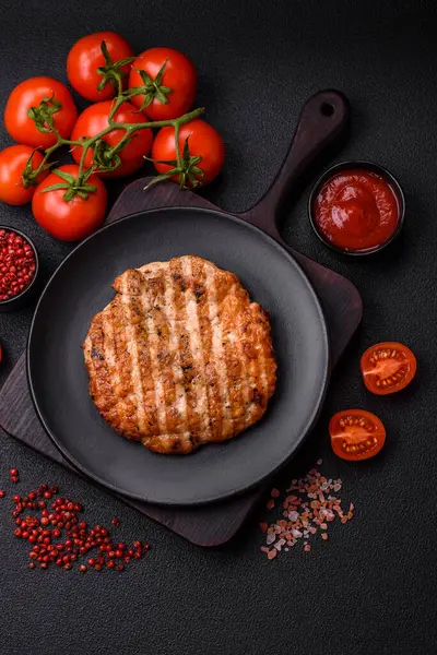 Lezzetli taze ızgara tavuk filetosu, esrarlı baharatlar ve çimento kaplı otlar. Ateşte pişirilmiş bir tabak.