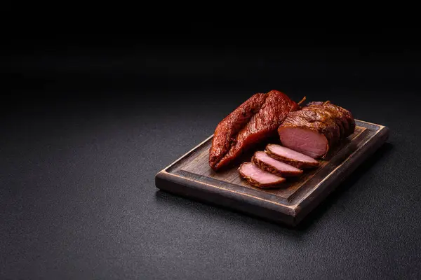 Delicious smoked meat pork or chicken with salt, spices and herbs on a dark concrete background