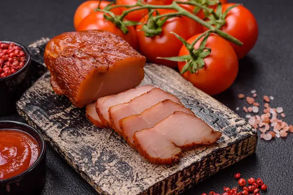 Delicious smoked meat chicken breast with salt, spices and herbs on a dark concrete background
