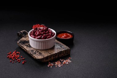 Sağlıklı bir kahvaltı hazırlamak için beyaz kasede tuzlu ve baharatlı konserve fasulye.