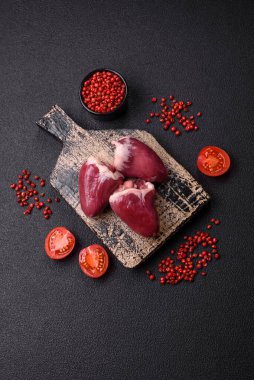 Çiğ hindi ya da arka planda tuzlu ve baharatlı tavuk kalbi.