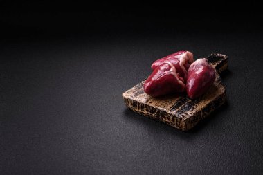 Çiğ hindi ya da arka planda tuzlu ve baharatlı tavuk kalbi.