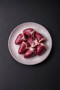 Çiğ hindi ya da arka planda tuzlu ve baharatlı tavuk kalbi.