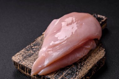 Koyu beton bir masada baharat ve otlarla taze tavuk filetosu. Et yemekleri için hazırlık.