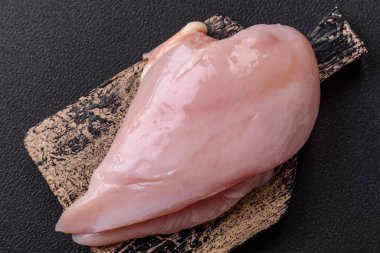 Koyu beton bir masada baharat ve otlarla taze tavuk filetosu. Et yemekleri için hazırlık.