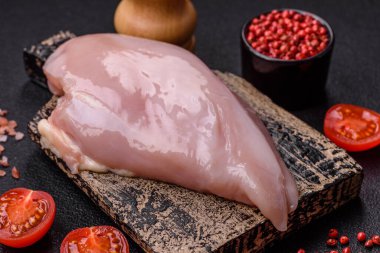 Koyu beton bir masada baharat ve otlarla taze tavuk filetosu. Et yemekleri için hazırlık.