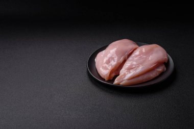 Koyu beton bir masada baharat ve otlarla taze tavuk filetosu. Et yemekleri için hazırlık.