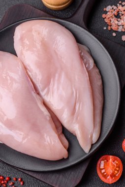 Koyu beton bir masada baharat ve otlarla taze tavuk filetosu. Et yemekleri için hazırlık.