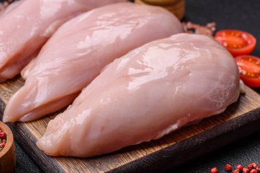 Koyu beton bir masada baharat ve otlarla taze tavuk filetosu. Et yemekleri için hazırlık.