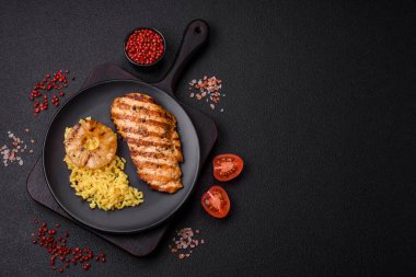 Lezzetli taze ızgara tavuk filetosu, esrarlı baharatlar ve çimento kaplı otlar. Ateşte pişirilmiş bir tabak.