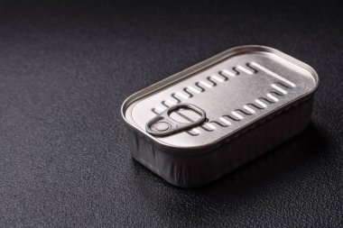 Koyu beton bir arka planda tuz ve baharatla yağlı dikdörtgen balık konservesi