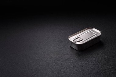 Koyu beton bir arka planda tuz ve baharatla yağlı dikdörtgen balık konservesi