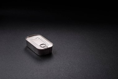 Koyu beton bir arka planda tuz ve baharatla yağlı dikdörtgen balık konservesi