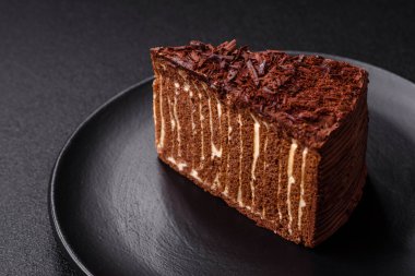 Lezzetli taze cheesecake keki ya da koyu beton arka planda seramik tabakta kremalı ve fındıklı snickers.