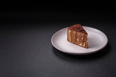 Lezzetli taze cheesecake keki ya da koyu beton arka planda seramik tabakta kremalı ve fındıklı snickers.