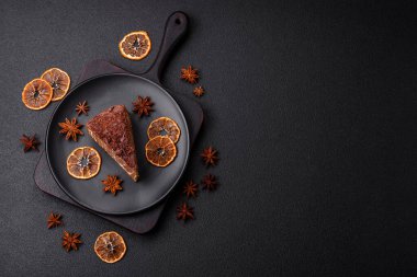 Lezzetli taze cheesecake keki ya da koyu beton arka planda seramik tabakta kremalı ve fındıklı snickers.