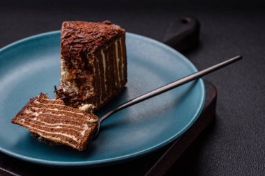 Lezzetli taze cheesecake keki ya da koyu beton arka planda seramik tabakta kremalı ve fındıklı snickers.