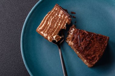 Lezzetli taze cheesecake keki ya da koyu beton arka planda seramik tabakta kremalı ve fındıklı snickers.