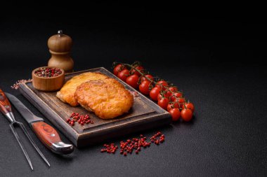 Dijon hardalıyla kızartılmış lezzetli et. Tuz, baharat ve otlarla birlikte koyu beton bir arka planda.