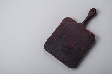 Gri desenli beton arka planda boş tahta kesme tahtası. Çatal bıçak takımı, akşam yemeği için hazırlık.