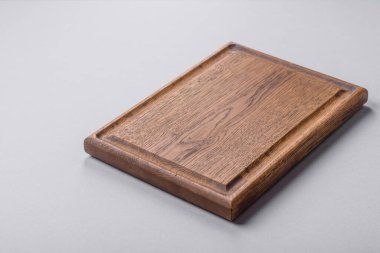 Gri desenli beton arka planda boş tahta kesme tahtası. Çatal bıçak takımı, akşam yemeği için hazırlık.