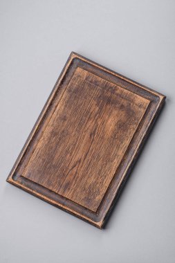 Gri desenli beton arka planda boş tahta kesme tahtası. Çatal bıçak takımı, akşam yemeği için hazırlık.