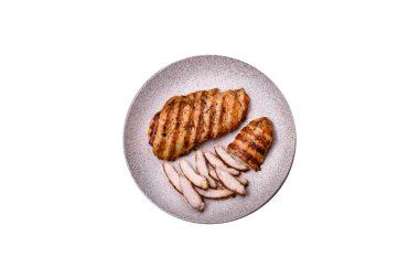 Lezzetli taze ızgara tavuk filetosu, esrarlı baharatlar ve çimento kaplı otlar. Ateşte pişirilmiş bir tabak.