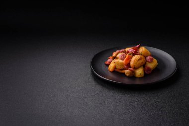 Izgara patates dilimlenmiş, sarımsak, soğan, tuz, baharat ve çimento kaplı sosislerle birlikte.