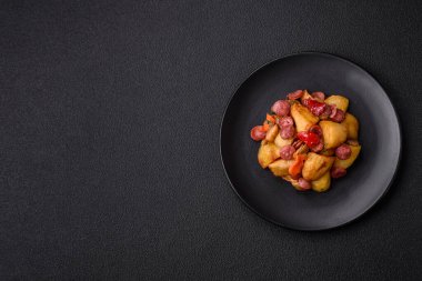 Izgara patates dilimlenmiş, sarımsak, soğan, tuz, baharat ve çimento kaplı sosislerle birlikte.