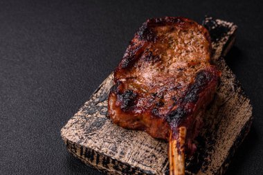 Kemiğin üzerinde leziz bir biftek, balta, tuz, baharat ve çimento kaplı otlar.