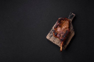 Kemiğin üzerinde leziz bir biftek, balta, tuz, baharat ve çimento kaplı otlar.