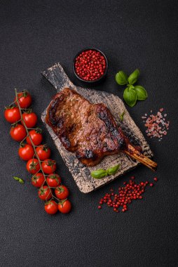 Kemiğin üzerinde leziz bir biftek, balta, tuz, baharat ve çimento kaplı otlar.