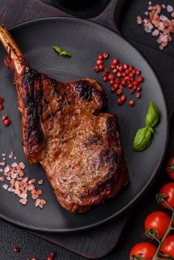 Kemiğin üzerinde leziz bir biftek, balta, tuz, baharat ve çimento kaplı otlar.