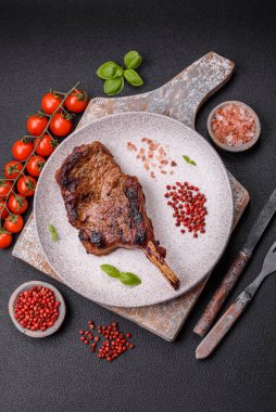 Kemiğin üzerinde leziz bir biftek, balta, tuz, baharat ve çimento kaplı otlar.