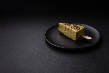 Koyu beton bir arka planda, ahşap bir çubukla meyveli lezzetli bir cheesecake.