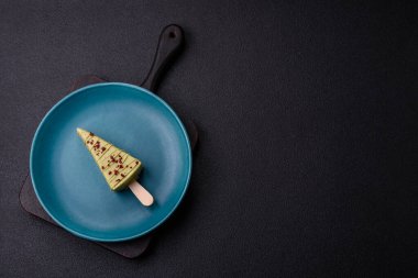 Koyu beton bir arka planda, ahşap bir çubukla meyveli lezzetli bir cheesecake.