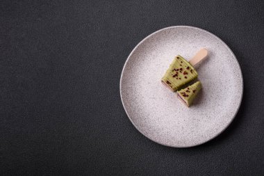 Koyu beton bir arka planda, ahşap bir çubukla meyveli lezzetli bir cheesecake.