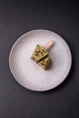 Koyu beton bir arka planda, ahşap bir çubukla meyveli lezzetli bir cheesecake.