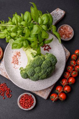 Dal şeklinde taze çiğ brokoli. Koyu beton bir arka planda evde yemek pişirmek için bir malzeme.