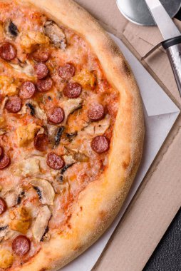 Sosisli, peynirli, domatesli, tuzlu, baharatlı ve çimento kaplı lezzetli bir pizza.