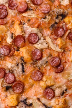 Sosisli, peynirli, domatesli, tuzlu, baharatlı ve çimento kaplı lezzetli bir pizza.