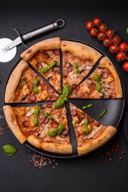 Sosisli, peynirli, domatesli, tuzlu, baharatlı ve çimento kaplı lezzetli bir pizza.