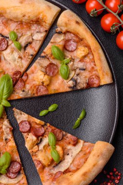 Sosisli, peynirli, domatesli, tuzlu, baharatlı ve çimento kaplı lezzetli bir pizza.