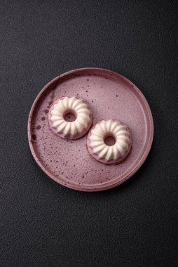 Lezzetli yuvarlak pembe ve beyaz cheesecake laktozsuz, şekersiz, sağlıklı beslenme koyu beton arka planda